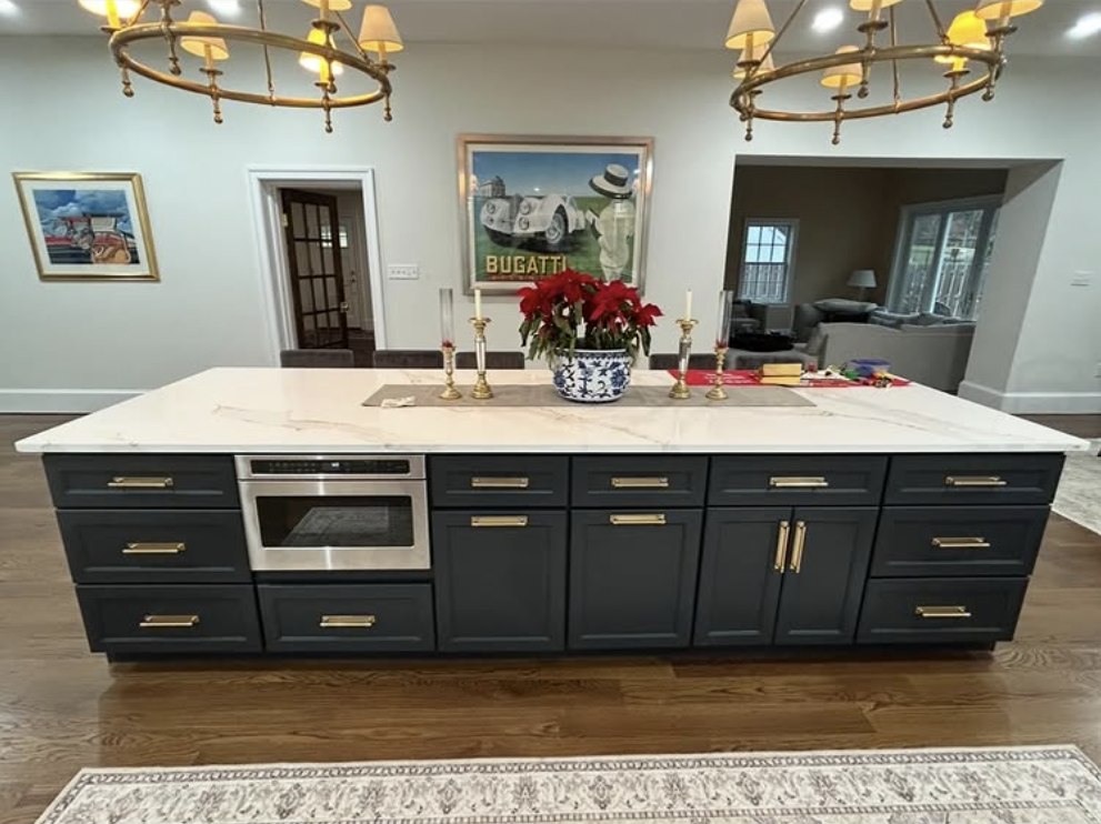 Stonewall Renovations kitchen island with dark cabinetry, brass hardware, and quartz countertop