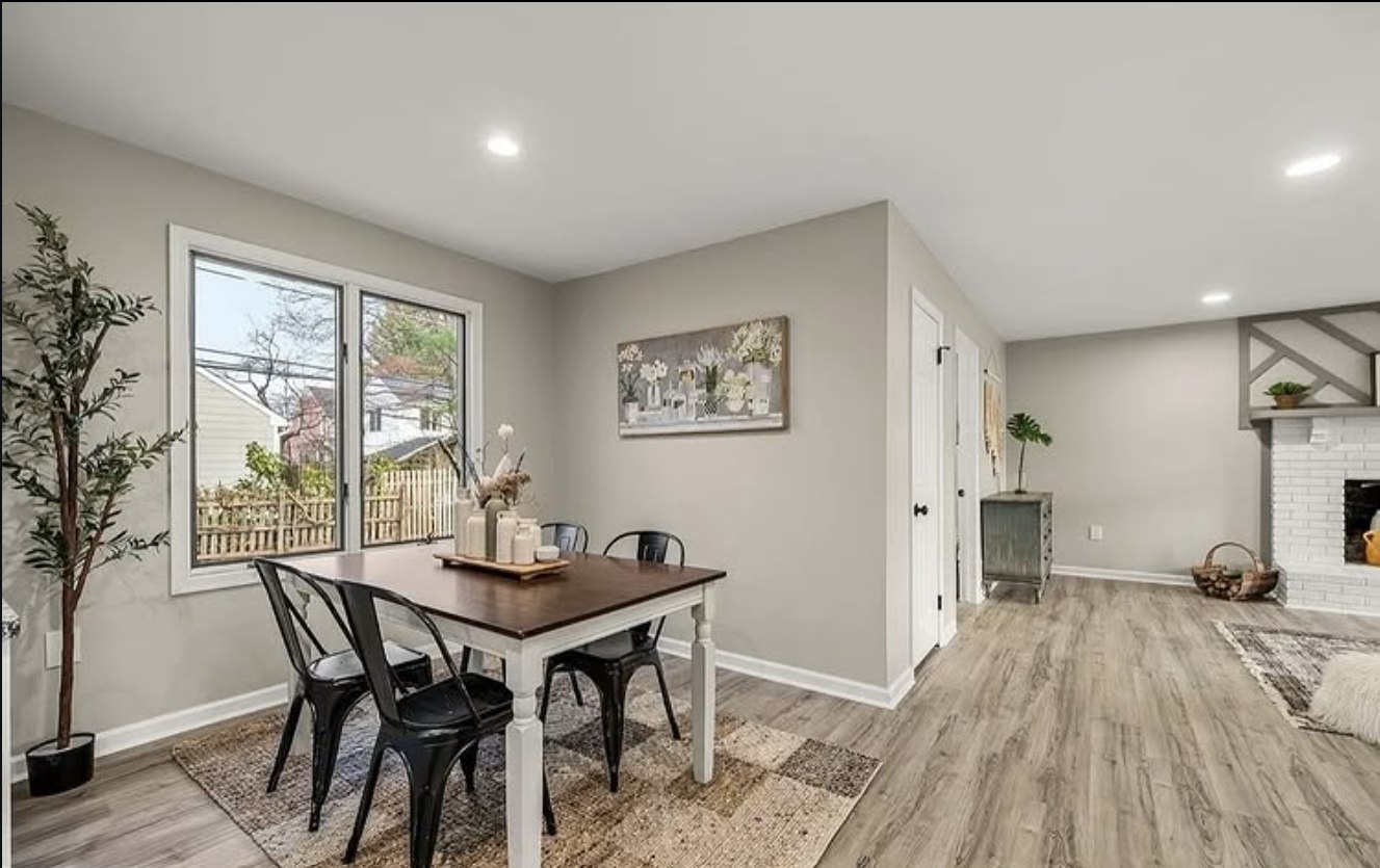 Stonewall Renovations open dining and living area with fireplace and plank flooring